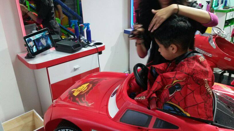 Niños durante su corte de cabello