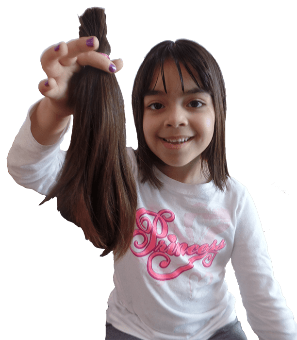 Niña mostrando su cabello largo para donarlo